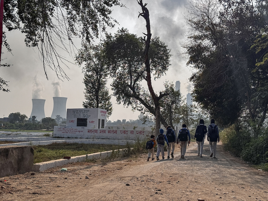 Students return home from Thakur Khambir Singh Harpayari De Middle School, amidst the backdrop of the Dadri thermal power plant, in Uncha Amipur village. 