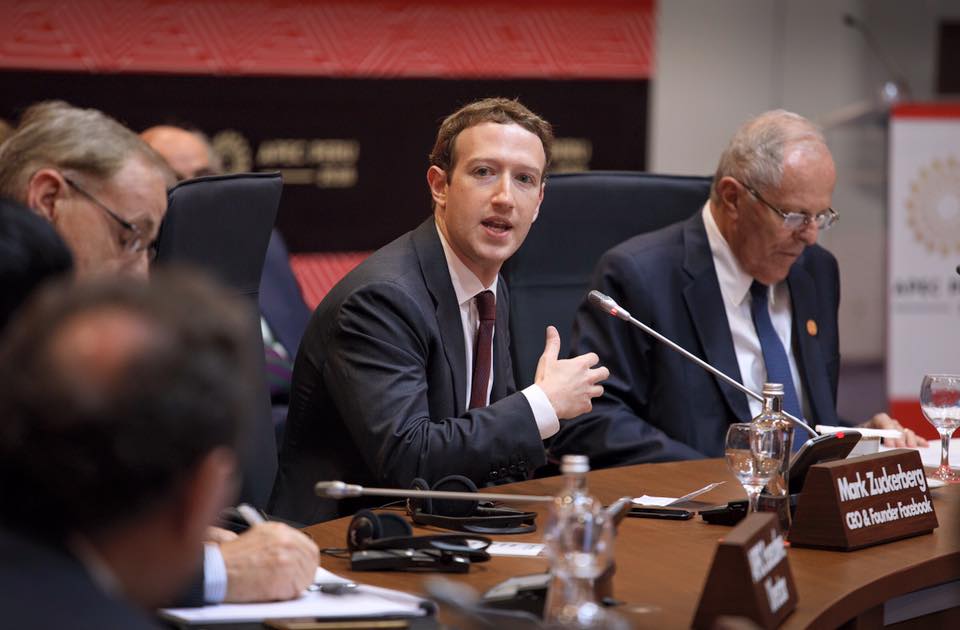 Photo of Mark Zuckerberg in a black suit, seated at an event, speaking into a microphone. Photo: Mark Zuckerberg/Facebook
