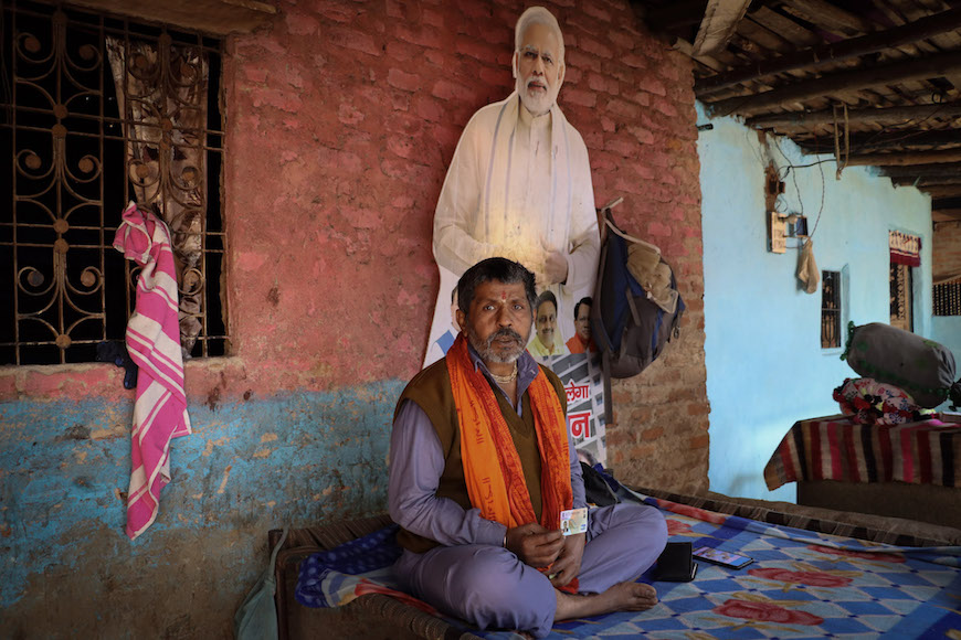 Sona Das in Delhi's refugee colony sits next to a cutout board of Indian Prime Minister Narendra Modi, whose citizenship law ushered in legal status for hundreds of Hindu refugees like him. Photo: Shivalika Puri