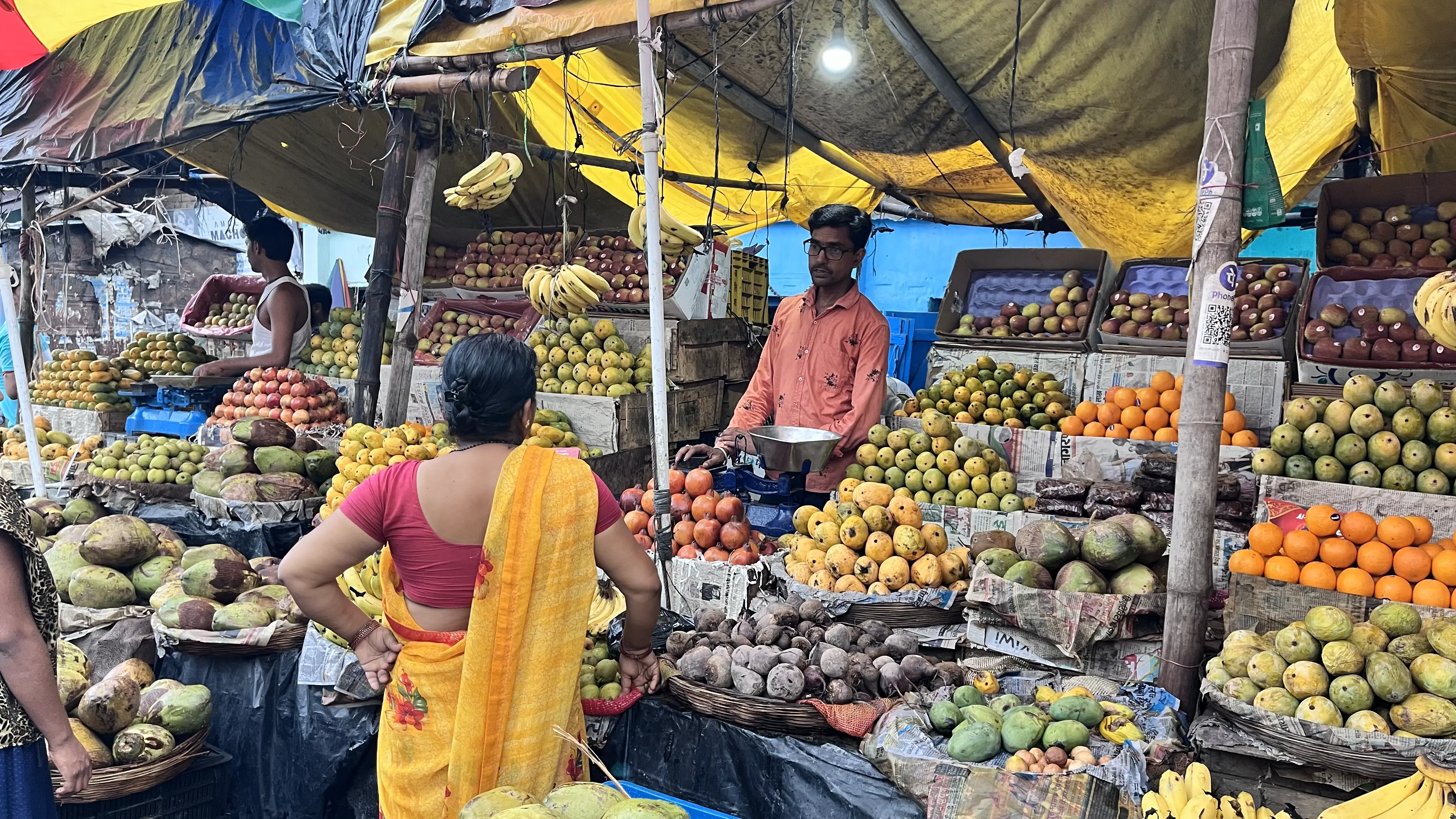 A local fruit vendor uses a bulb powered by electricity from Husk Power. Photo: Sneha Richhariya