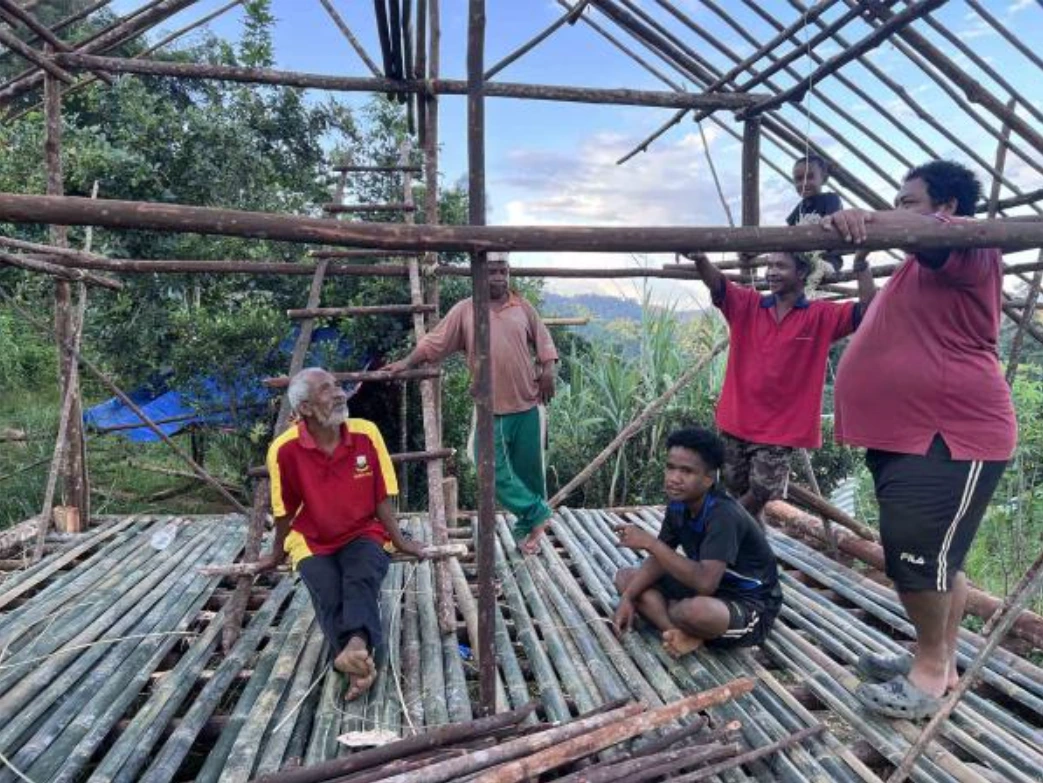 Azlan Ahak, 19, (sitting, right), with his father, Ahak Uda, 57, (sitting, left) and other relatives take a break from house building. Photo: Malaysiakini