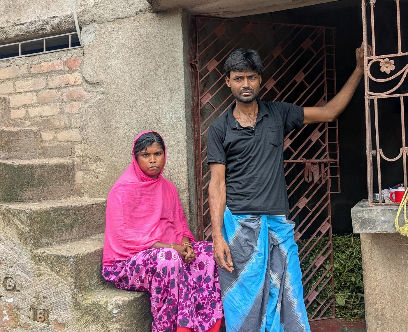 স্ত্রী সুরনা বিবির সঙ্গে মুর্শিদাবাদের বালিয়া হোসেন নগরে নিজেদের বাড়িতে মেহেবুব শেখ। ২০২৫-এর ৯ জুন এই পরিযায়ী রাজমিস্ত্রিকে তুলে নিয়ে যায় মহারাষ্ট্র পুলিশ, তাঁর নাগরিকত্বের প্রমাণ হিসেবে কাগজপত্র চায়। শেষপর্যন্ত তাঁকে জোর করে বাংলাদেশে রেখে আসা হয়। Photo: Anirban Dey/PARI