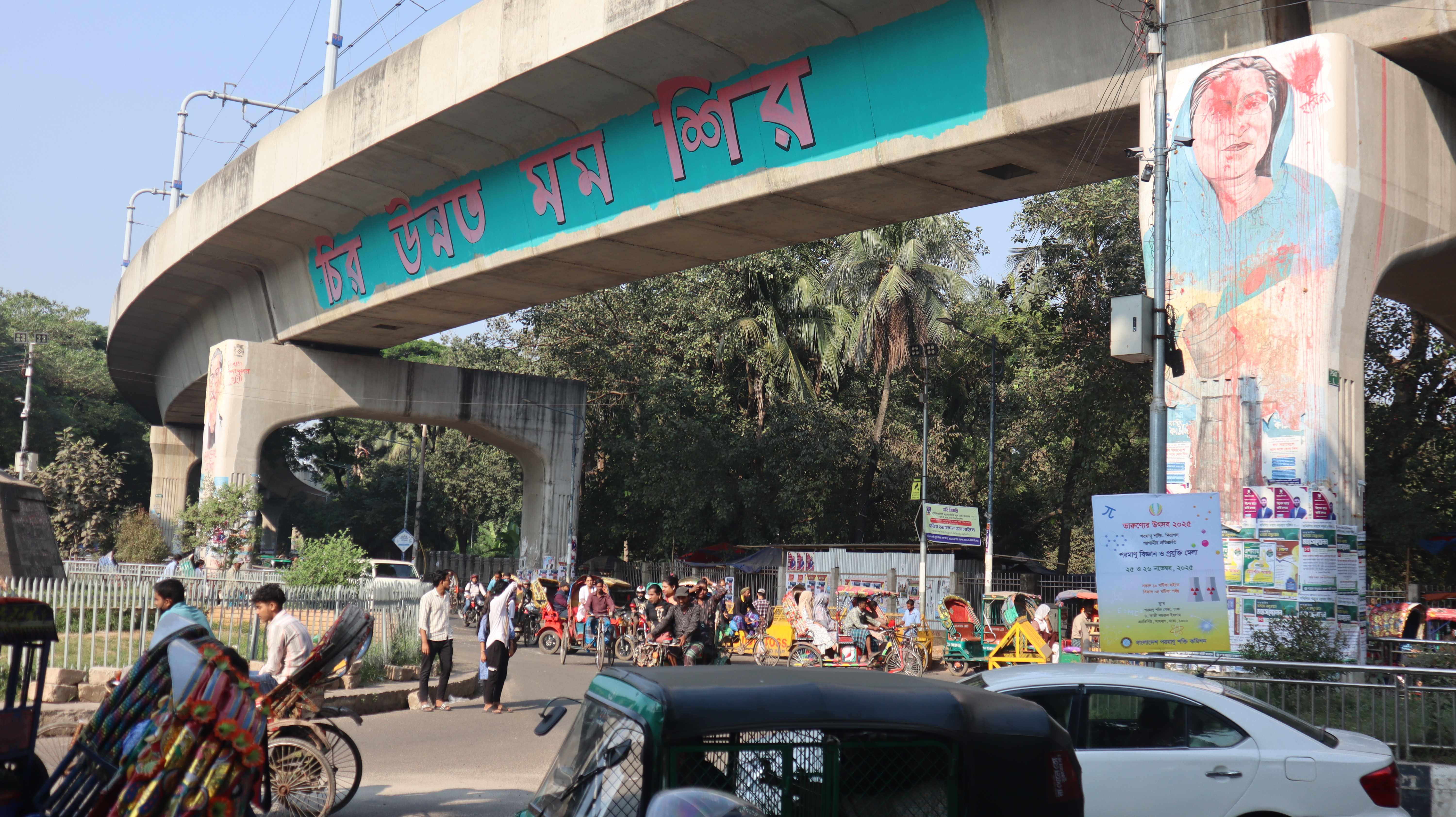 The image shows a disfigured mural of Sheikh Hasina at Dhaka University.