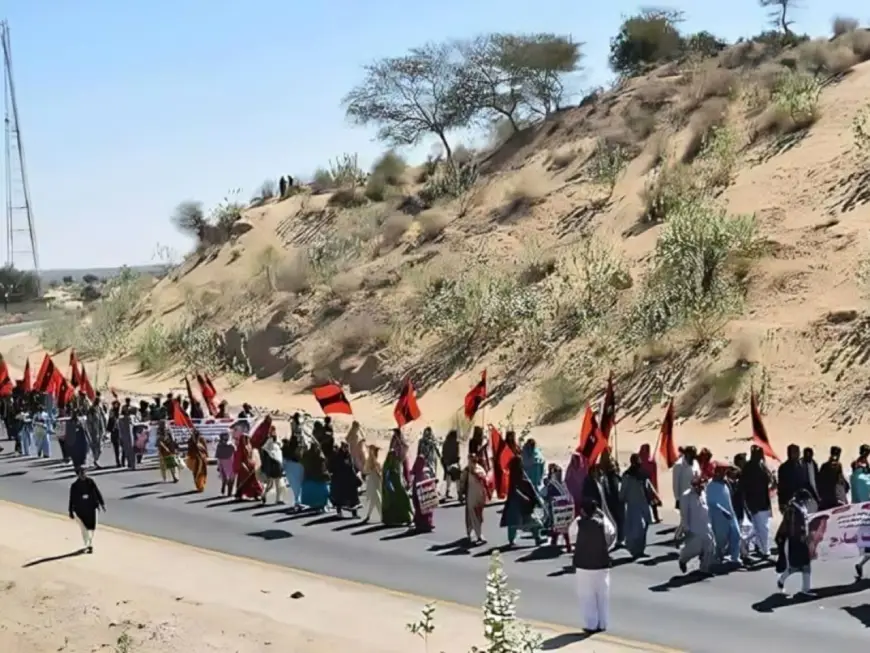 A long line of people marching together in the background of a arid desert for Awami Tehreek’s 2017 march in Tharparkar. Photo: Awami Tehreek/Earthwise